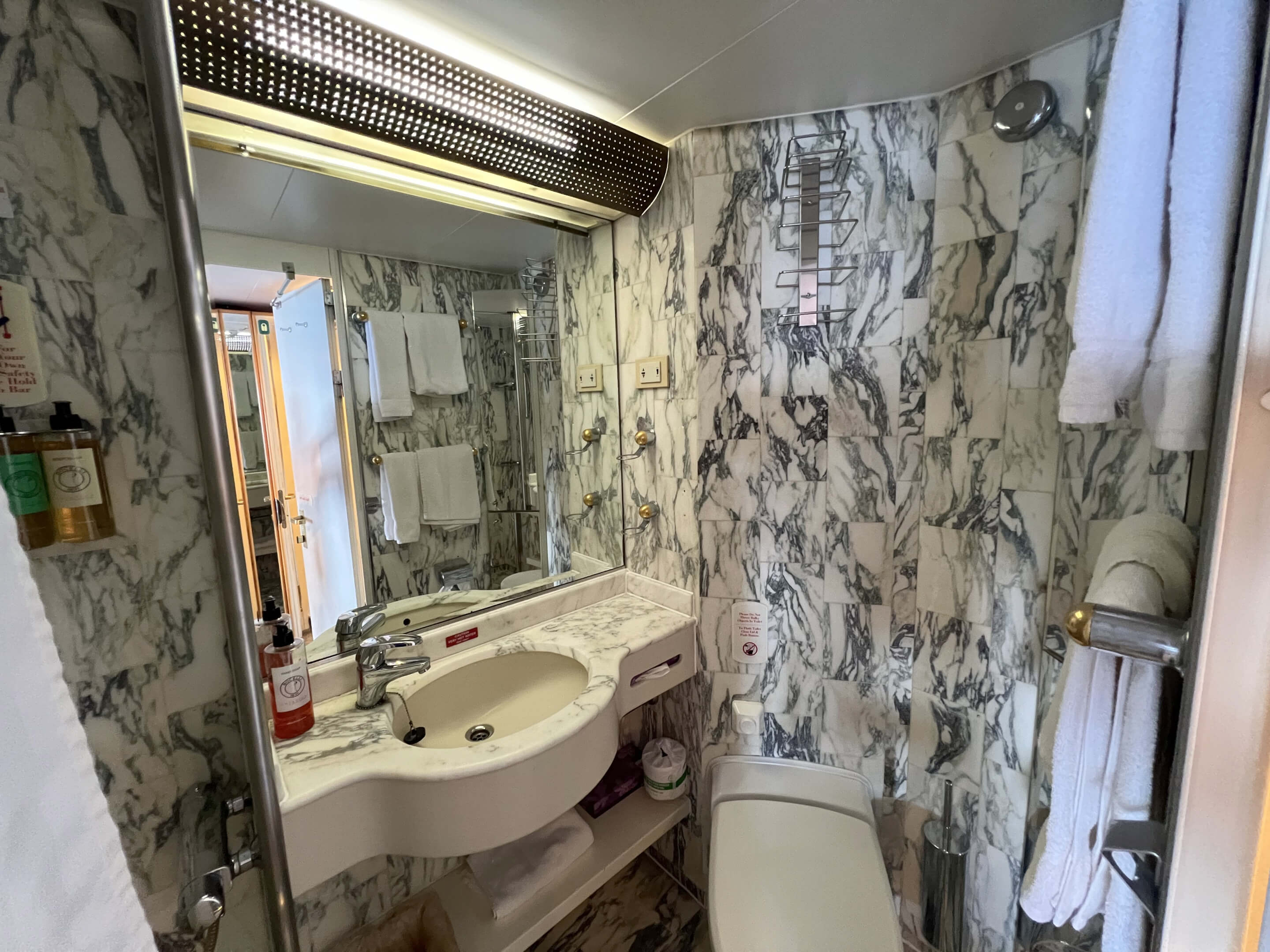 Bathroom with shower over a bath and twin basins